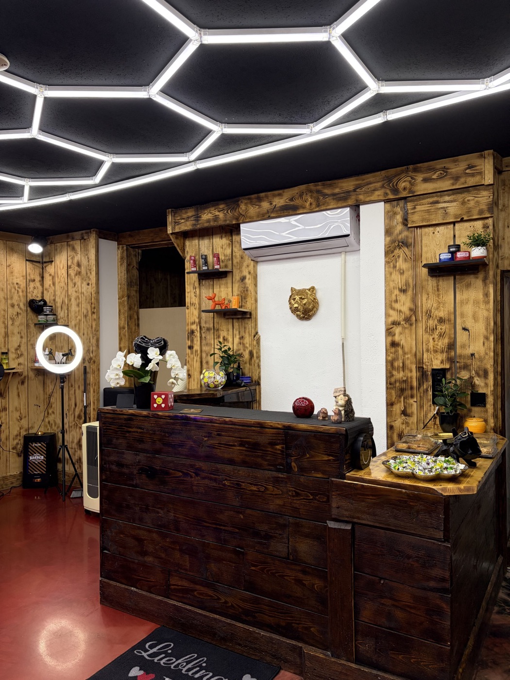 Innenraum des Barbershops mit Holzwand und Wabenlicht